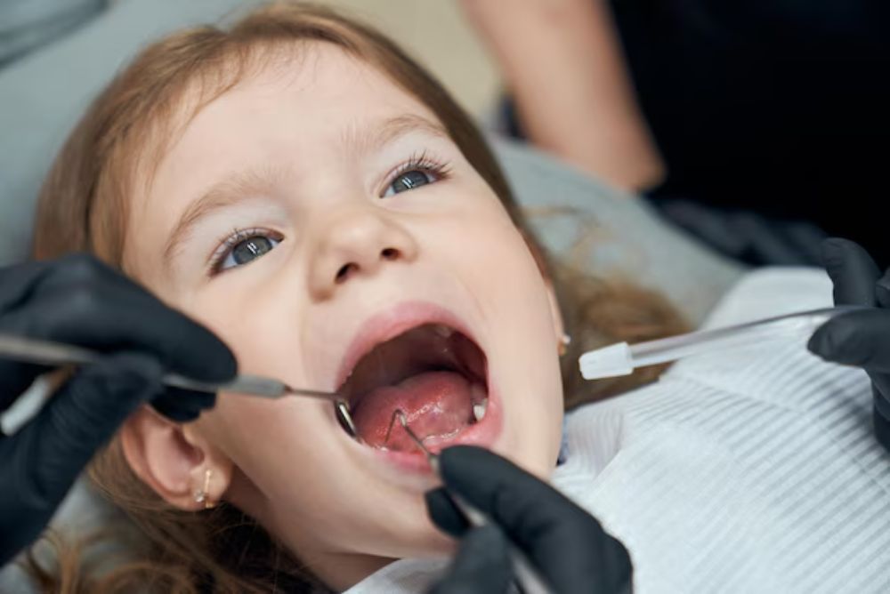 child with permanent tooth growing behind baby tooth